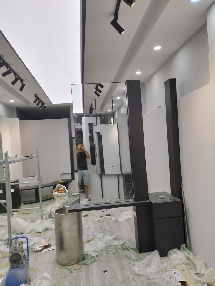 Thợ lắp đặt bàn gương khu vực ghế cắt trong giai đoạn hoàn thiện