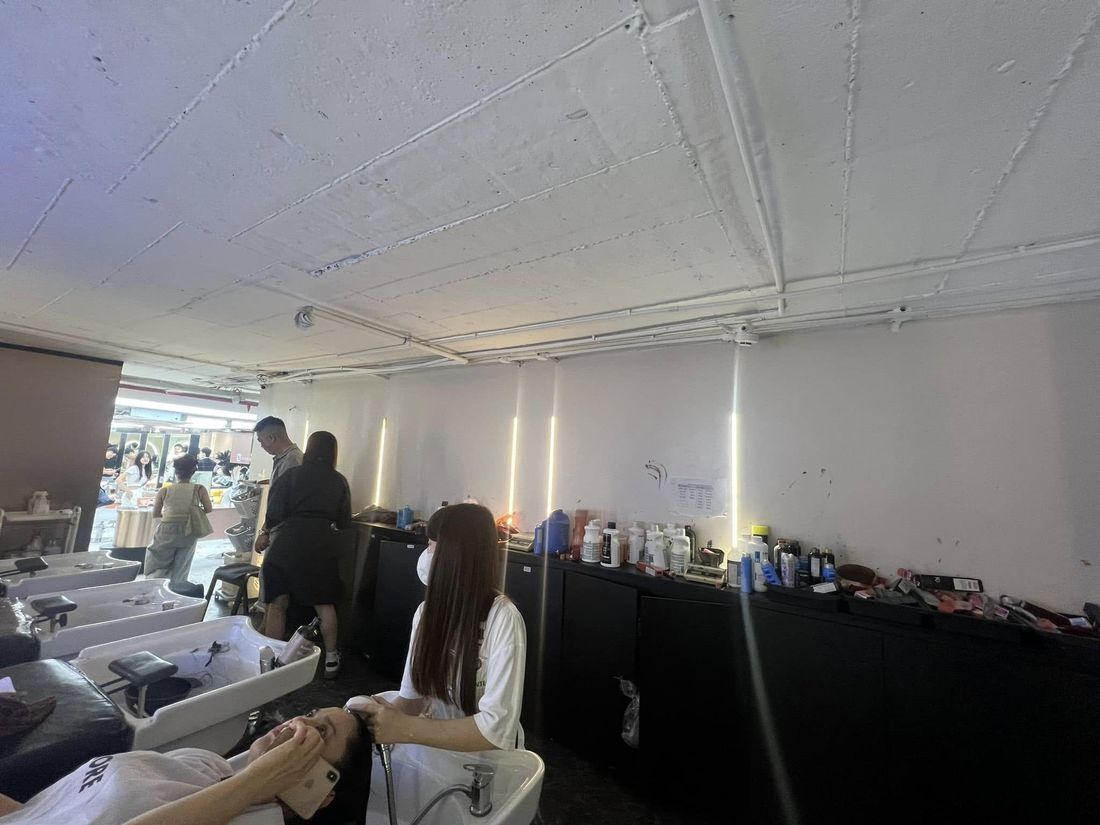 Ảnh thực tế khu ghế cắt và tạo kiểu tóc có khách tại salon NAM Hair Studio - Nội Thất Hà Tuấn LX