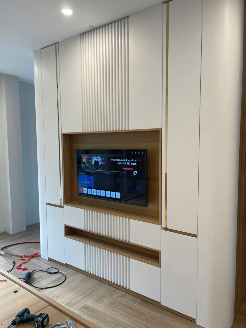 Vách tivi ốp lam trắng dọc hiện đại, tích hợp tivi treo tường - Nội Thất Hà Tuấn LX