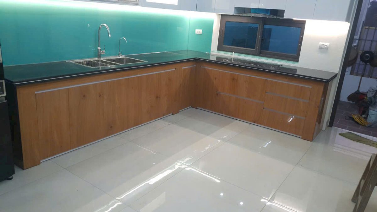 Tủ bếp chữ L gỗ tự nhiên phối kính ốp bếp xanh, tích hợp bồn rửa - Nội Thất Hà Tuấn LX