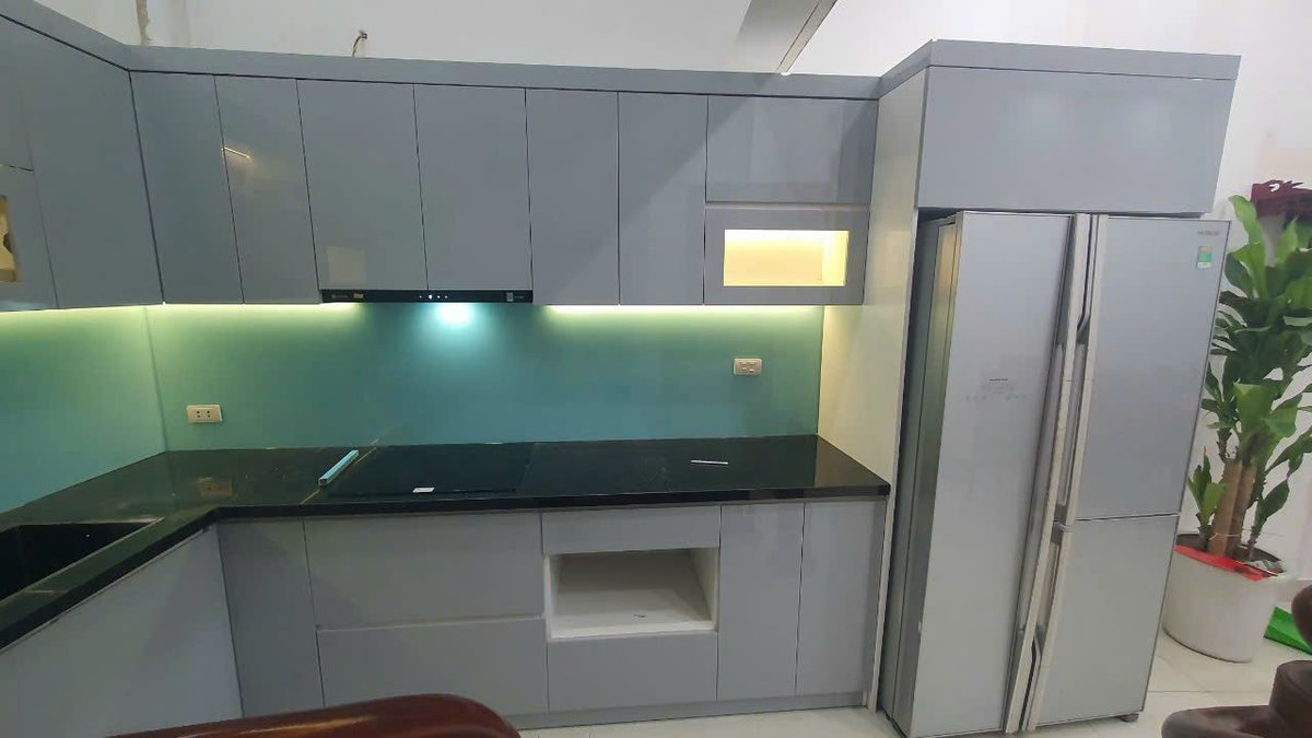 Tủ bếp chữ L cánh xám xanh, mặt đá xanh, tủ lạnh âm tủ gọn gàng - Nội Thất Hà Tuấn LX
