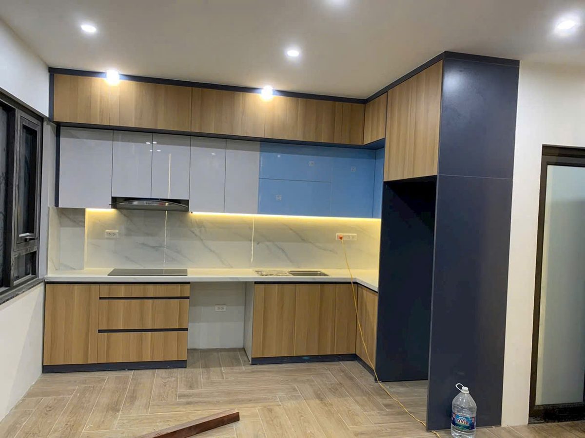 Tủ bếp phối gỗ và cánh trắng, máy hút mùi âm tủ, đèn LED dưới tủ trên - Nội Thất Hà Tuấn LX